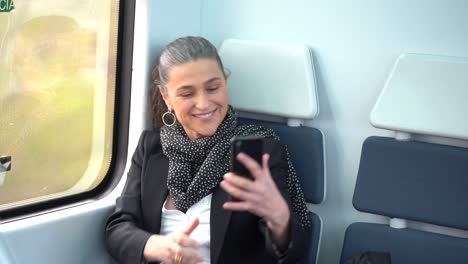 mujer madura sonriente tomando una foto mientras viaja en tren