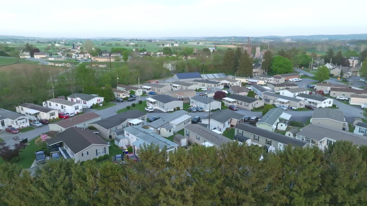 A drone glides over a tranquil suburban mobile home area as the day slowly fades into twilight