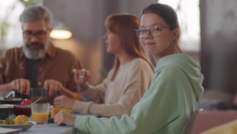 retrato de una adolescente alegre en una cena familiar