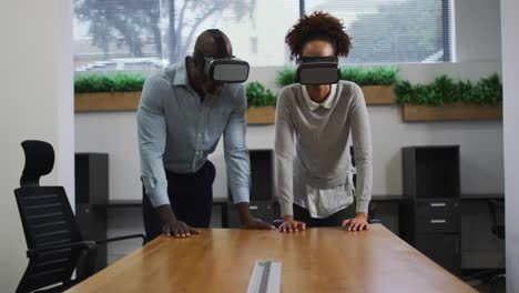 Diverse-male-and-female-business-colleagues-wearing-vr-headsets-in-office