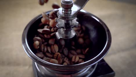 coffee beans fall in the old grinder. slow motion with rotation tracking shot.