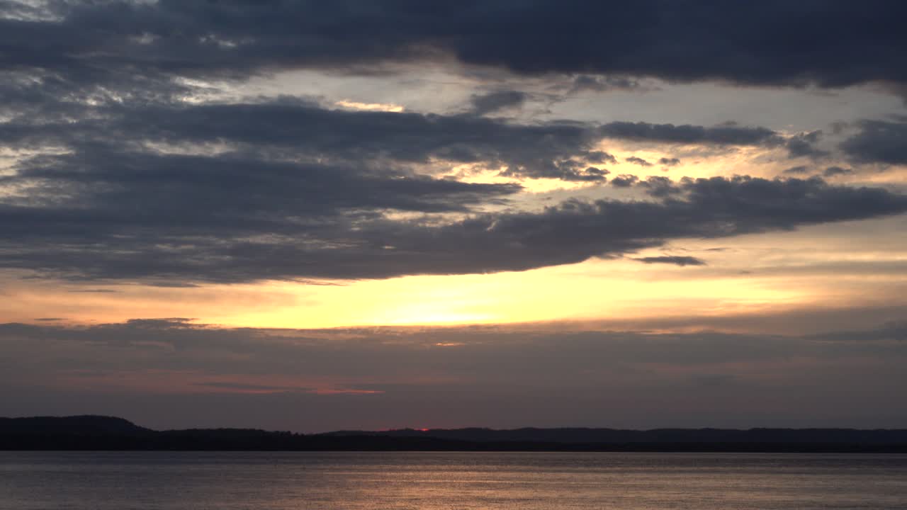 Dramatic Sunset Sky Reflected on Calm Lake Water