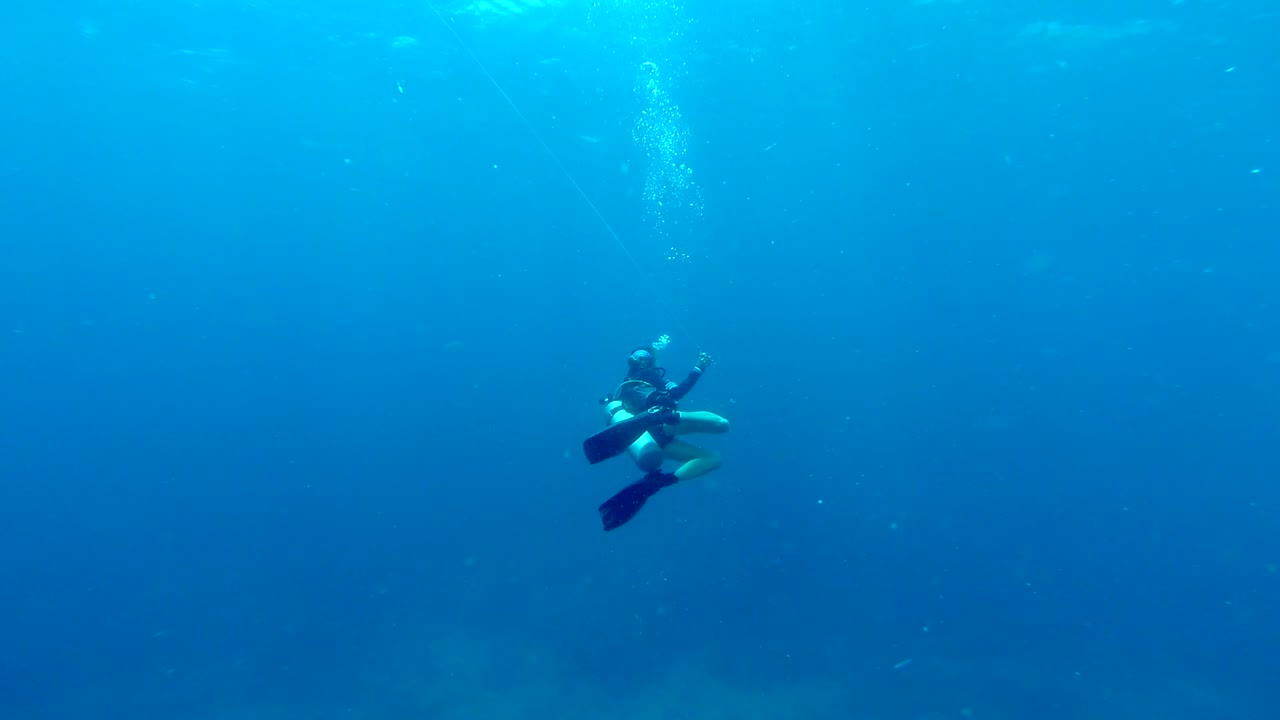 가이드 로프를 풀고 탁 트인 푸른 바다를 헤엄치는 고독한 스쿠버 다이버
