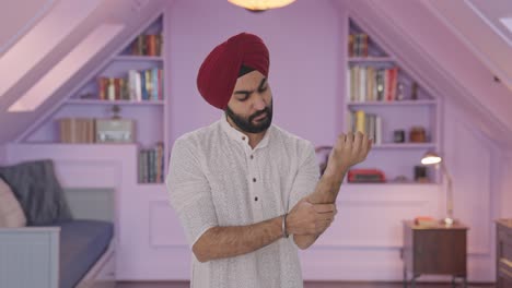 sick sikh indian man suffering from hand pain