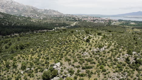 Epic-aerial-reveal-of-Manzanares-el-Real-and-the-Santillana-Reservoir-seen-from-the-foothills-of-the-Sierra-De-Guadarrama-in-Spain