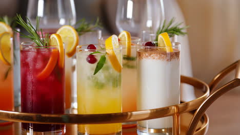 assorted colorful cocktails and mocktails on a golden serving tray