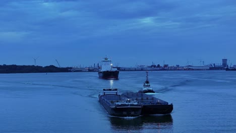 empty-garbage-scow-and-cargo-ship-leaving-the-harbor,-aerial