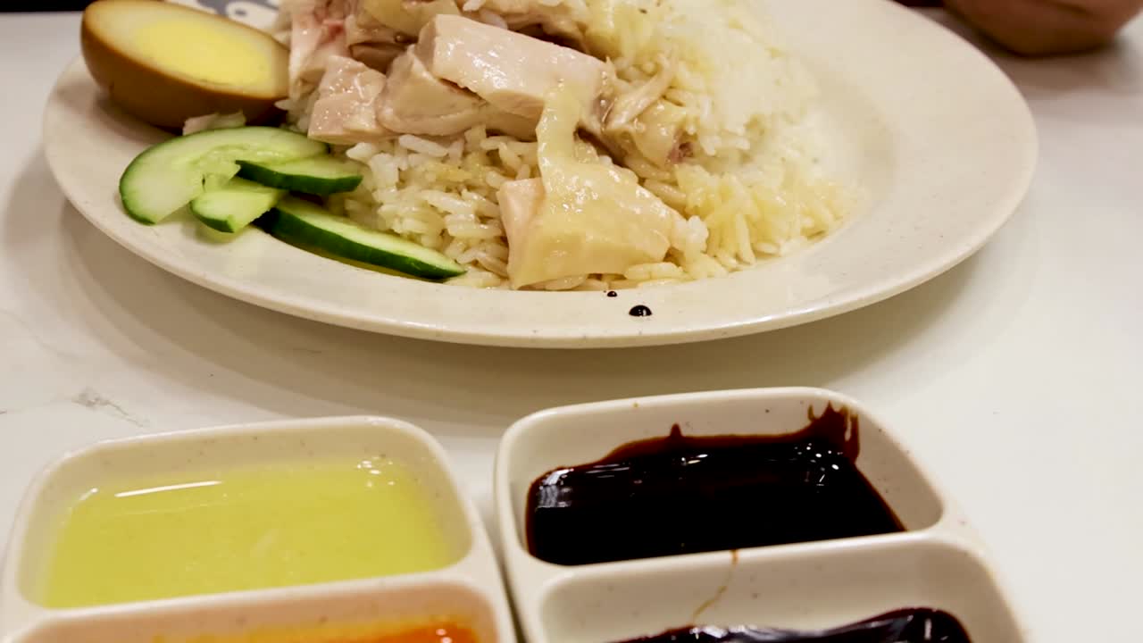 젓가락으로 찜닭을 집어 진한 간장에 찍는 근접 촬영.