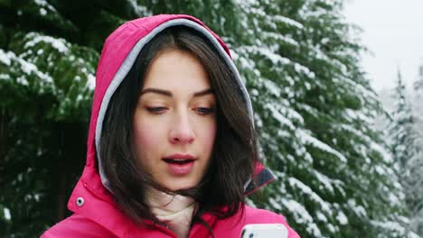 Smiling-woman-in-warm-clothing-using-mobile-phone