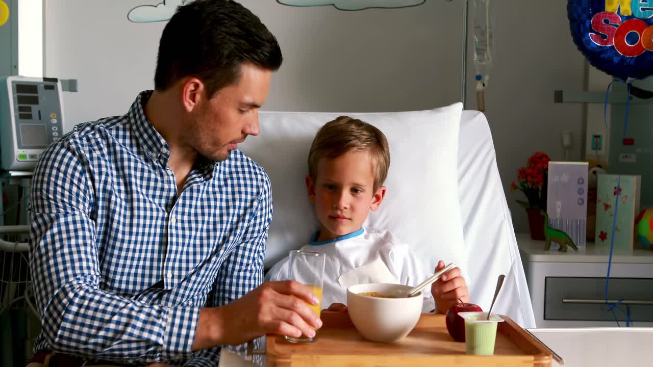 Father feeding breakfast to his son
