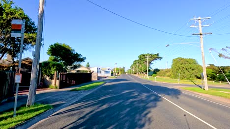a serene drive along a quiet road in bellarine, victoria, under clear blue skies with vibrant greenery