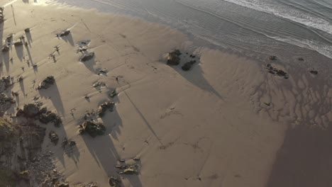 Toma-Aérea-Sin-Procesar-De-Un-Surfista-Caminando-Por-La-Playa-Hacia-La-Desembocadura-Del-Río-Bantham-Al-Amanecer