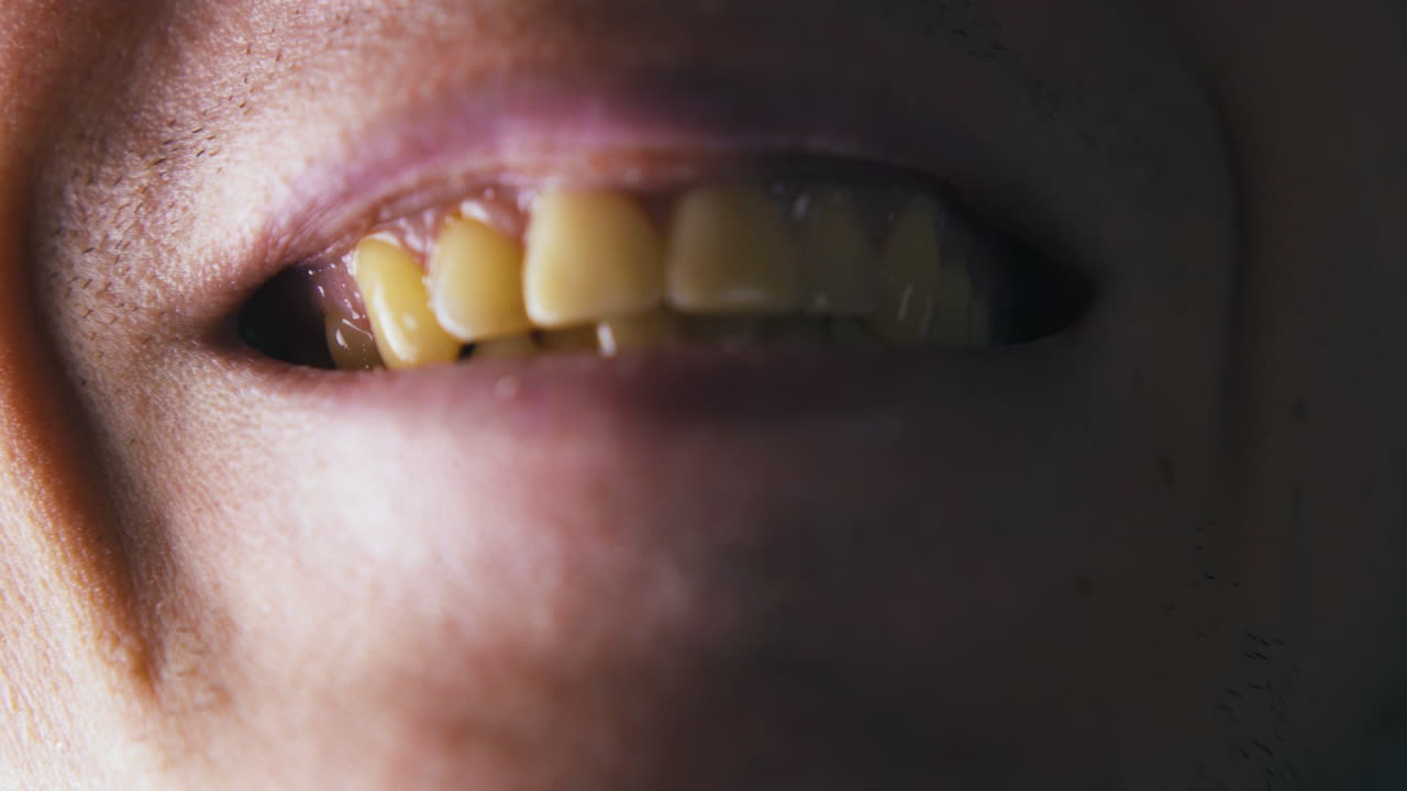 흐릿한 사람이 카메라 렌즈 매크로에 접근하고 숨을 쉬고 있습니다.