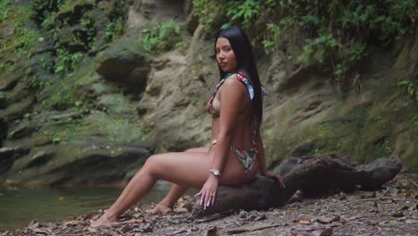 . a girl wearing a bikini by a cascading waterfall in the caribbean.