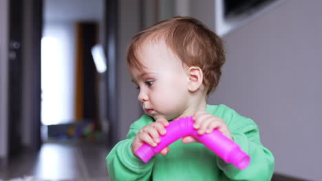 baby playing with a pink toy