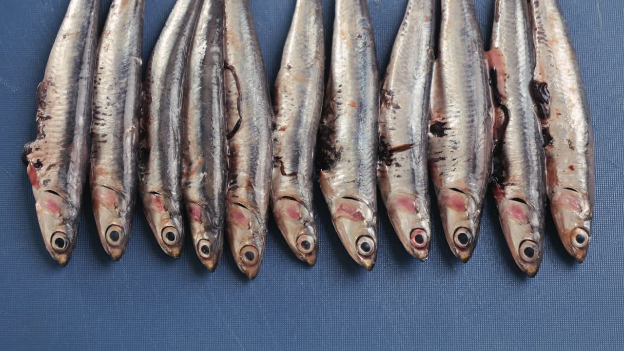 Anchovies on a blue cutting board