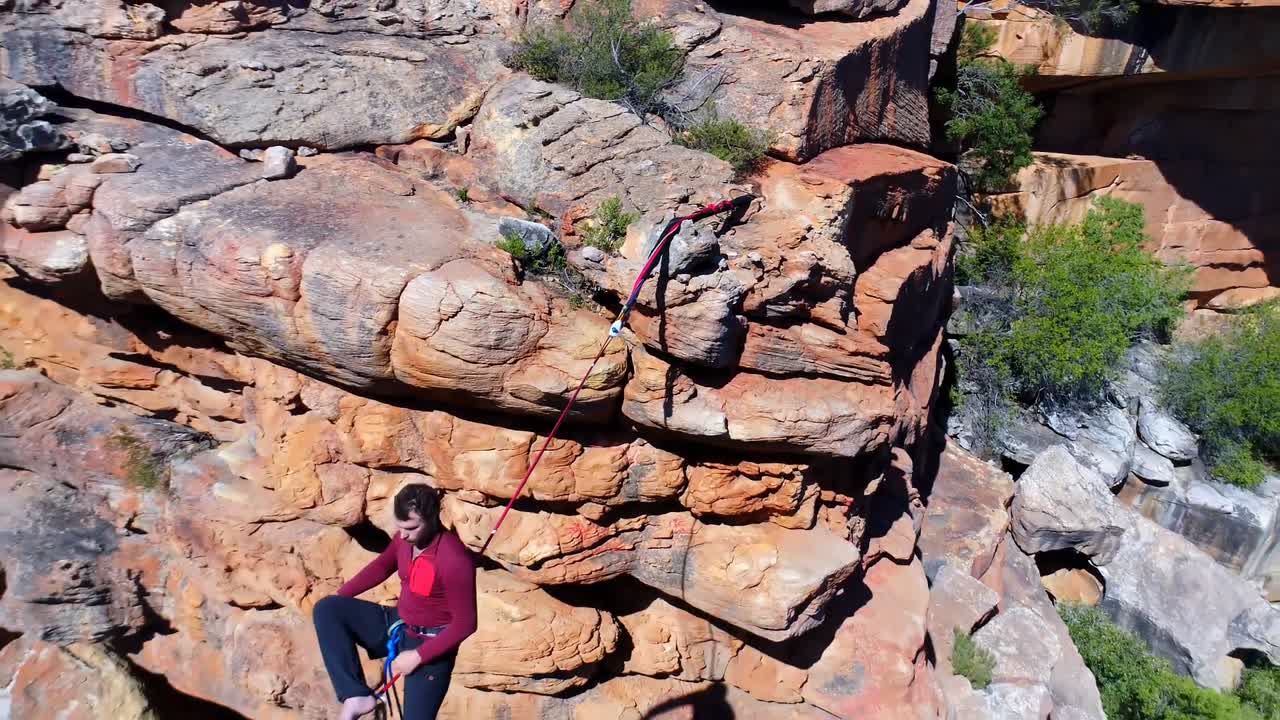 hombre caminando en una cuerda sobre las montañas rocosas 4k
