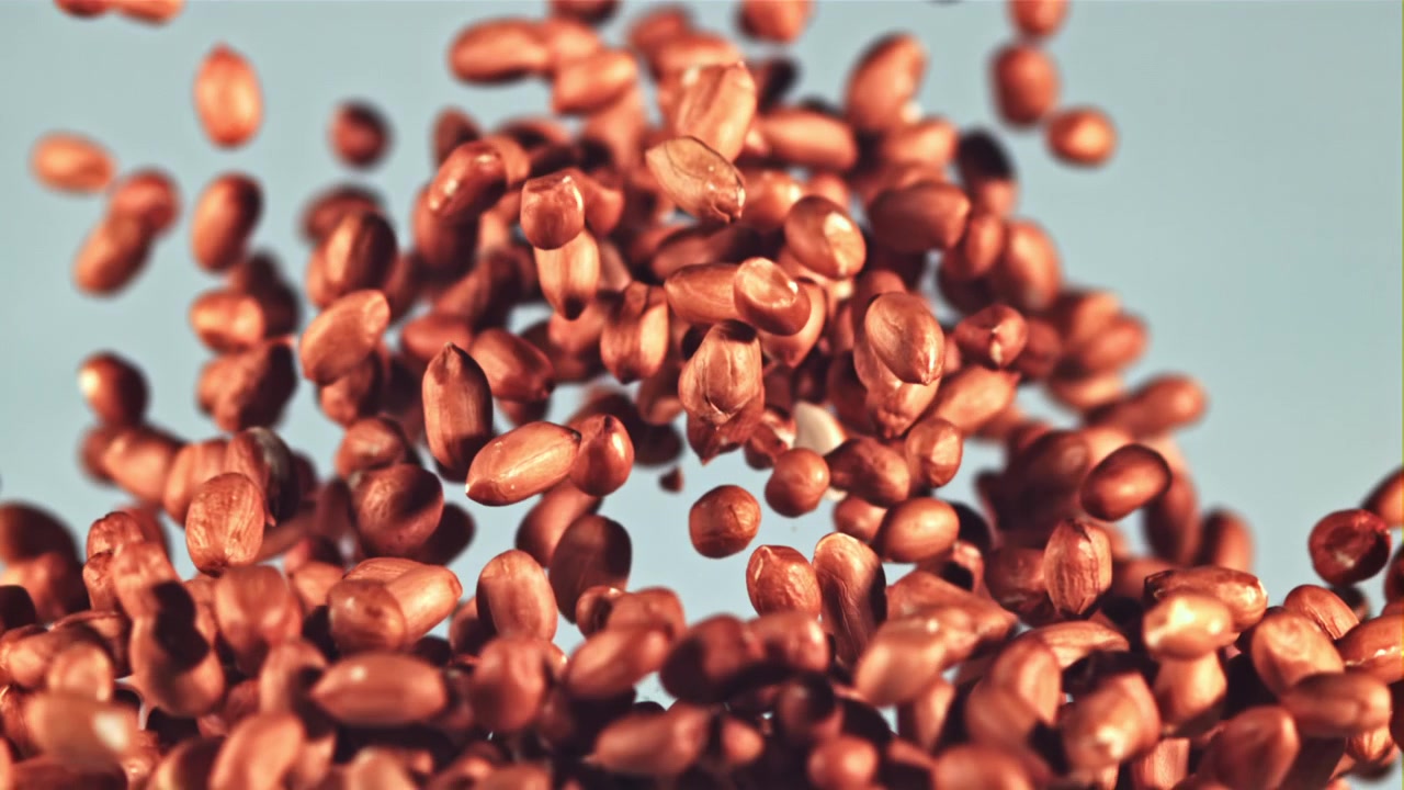 Peanuts Falling in Slow Motion Against a Light Blue Background