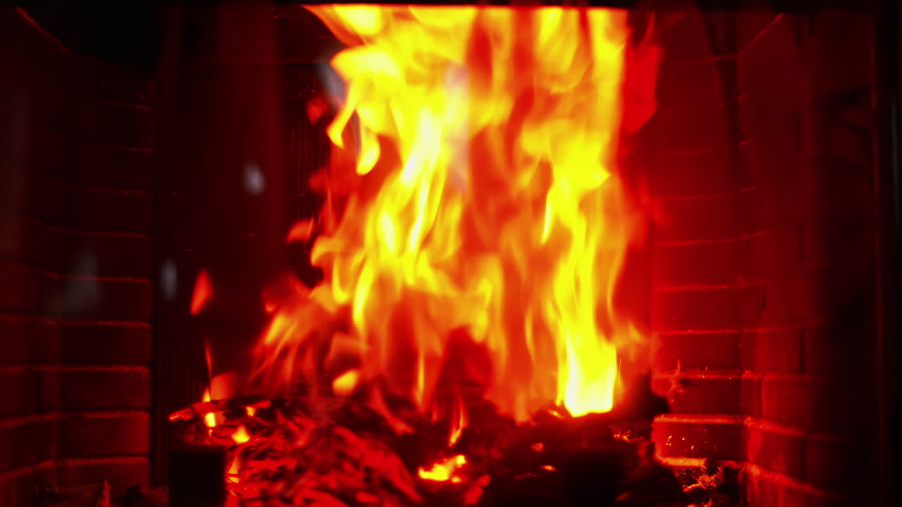Close up of a red flame burning wood in a fireplace
