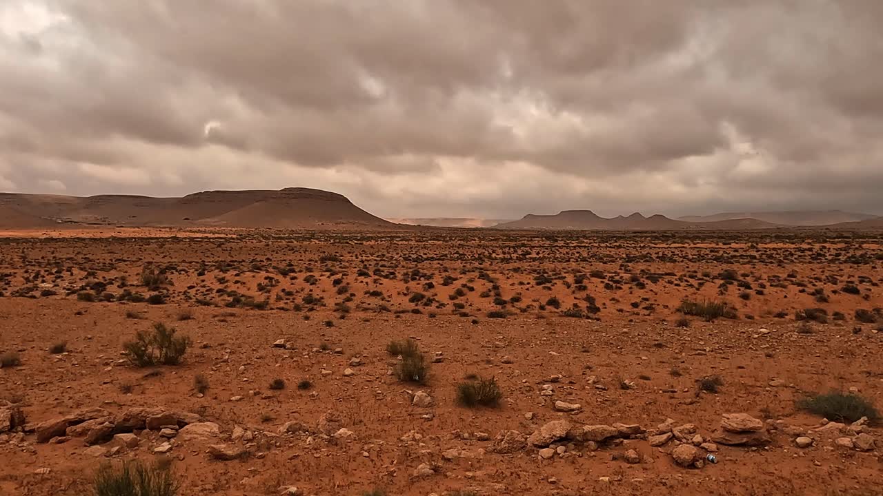 Paisagem desértica da Tunísia e céu nublado dramático visto da perspectiva de um passageiro de carro.