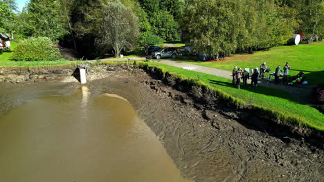men working at the pond during harvest season near rural village. aerial shot