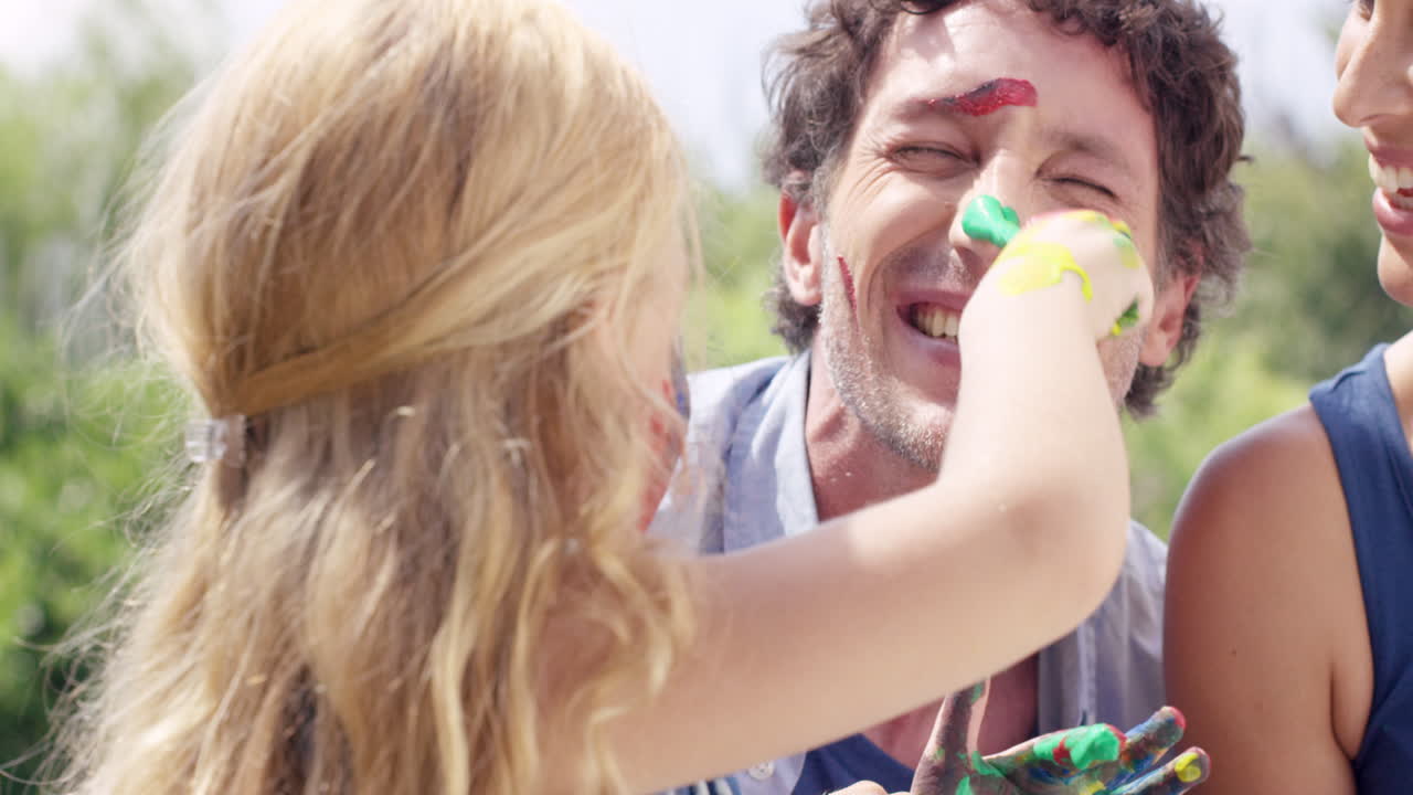 familia feliz con una niña pequeña pintando en el patio creativo con mamá y papá
