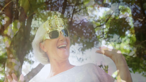 animation of glowing light over portrait of happy senior woman