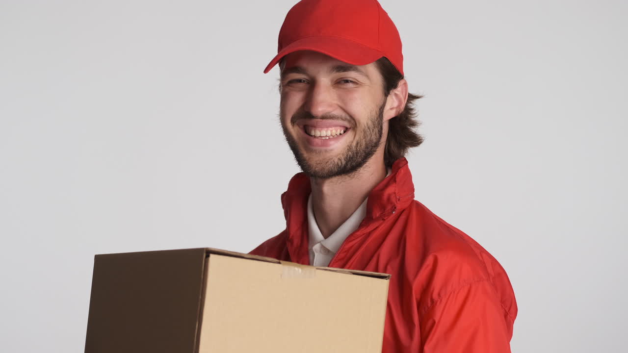 Caucasian delivery man in front of camera on white background.
