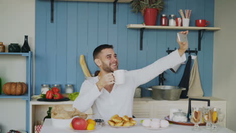 man taking a selfie while eating breakfast in the kitchen