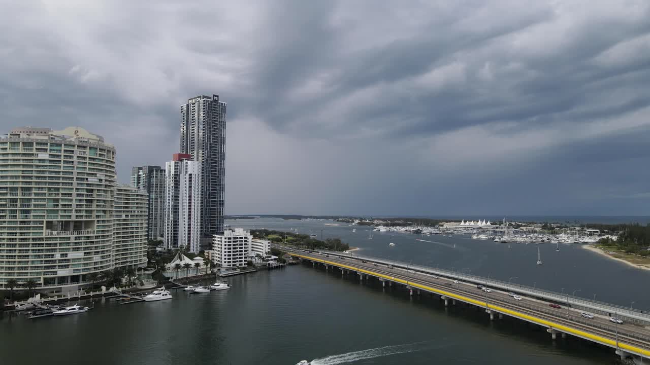 폭풍우를 배경으로 한 높은 고층 건물 옆에 있는 분주한 도로와 트램 교량을 내려다보는 높은 공중 전망