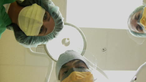 surgeons look down on a patient and use instruments in this pov shot