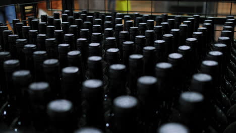 close-up of the tops of wine bottles lined up at a wine factory