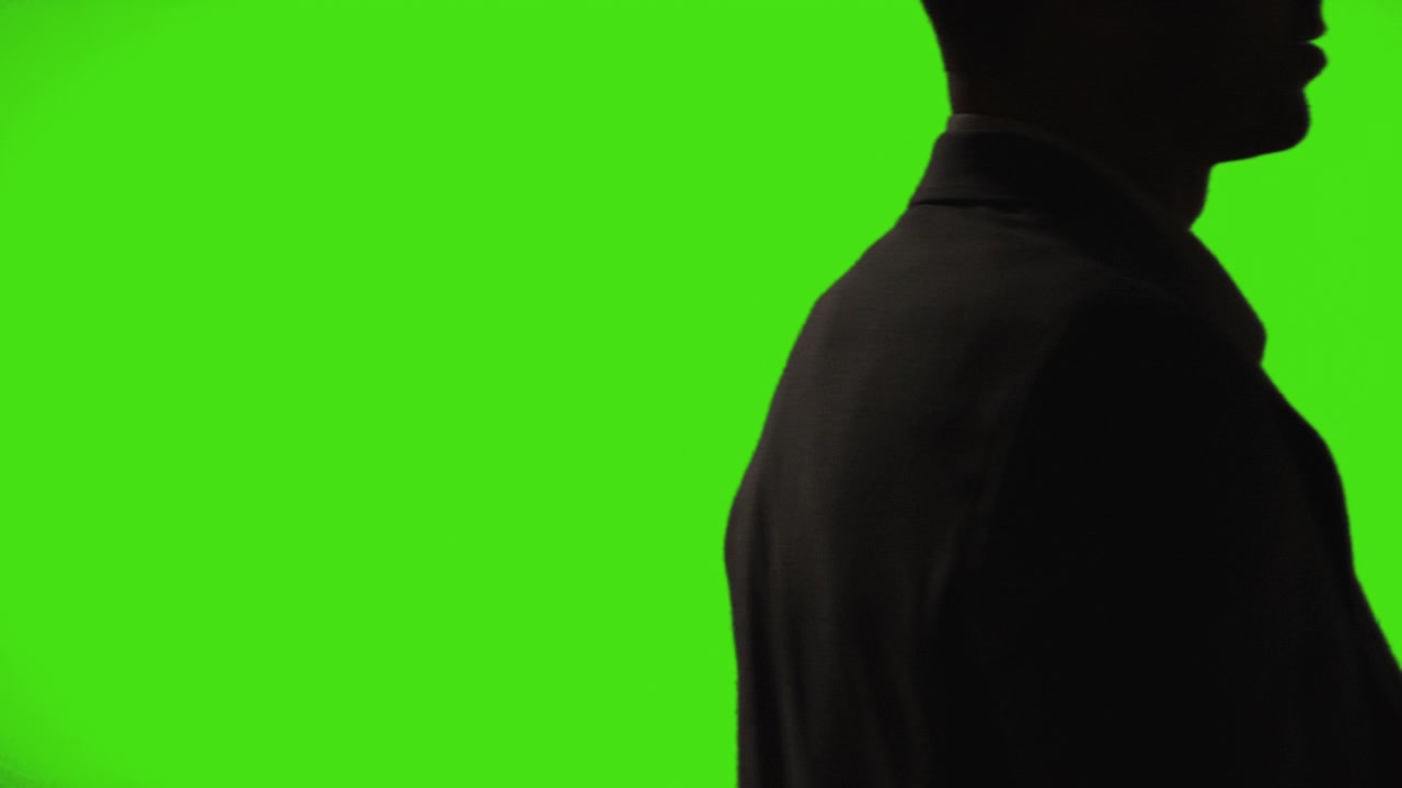 Close Up Silhouette Of Businessman Wearing Suit Walking Across Frame Against Green Screen Background 1