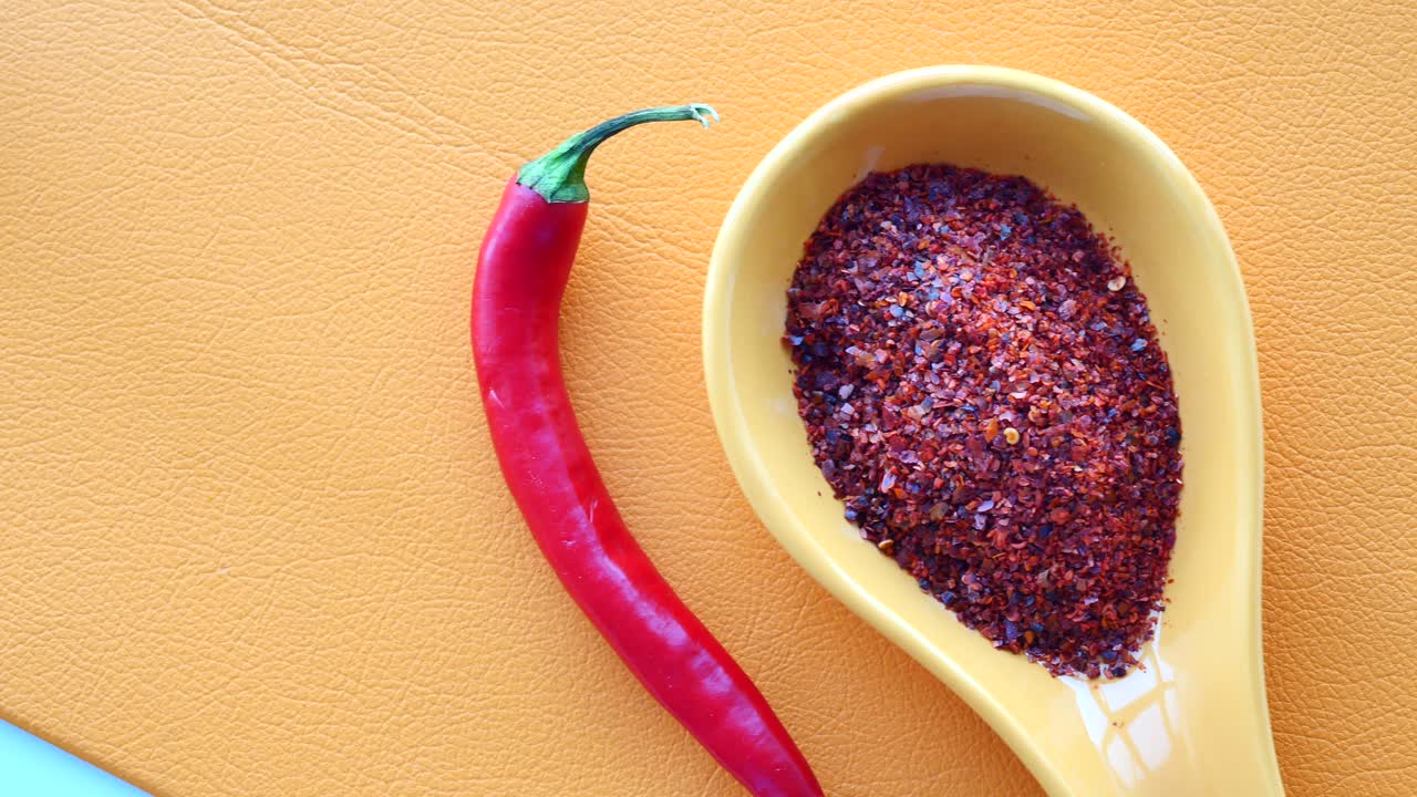 copos de pimienta roja y pimienta en una cuchara amarilla