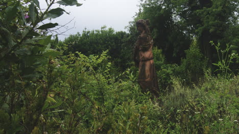 old statue in abandoned garden - handheld shot