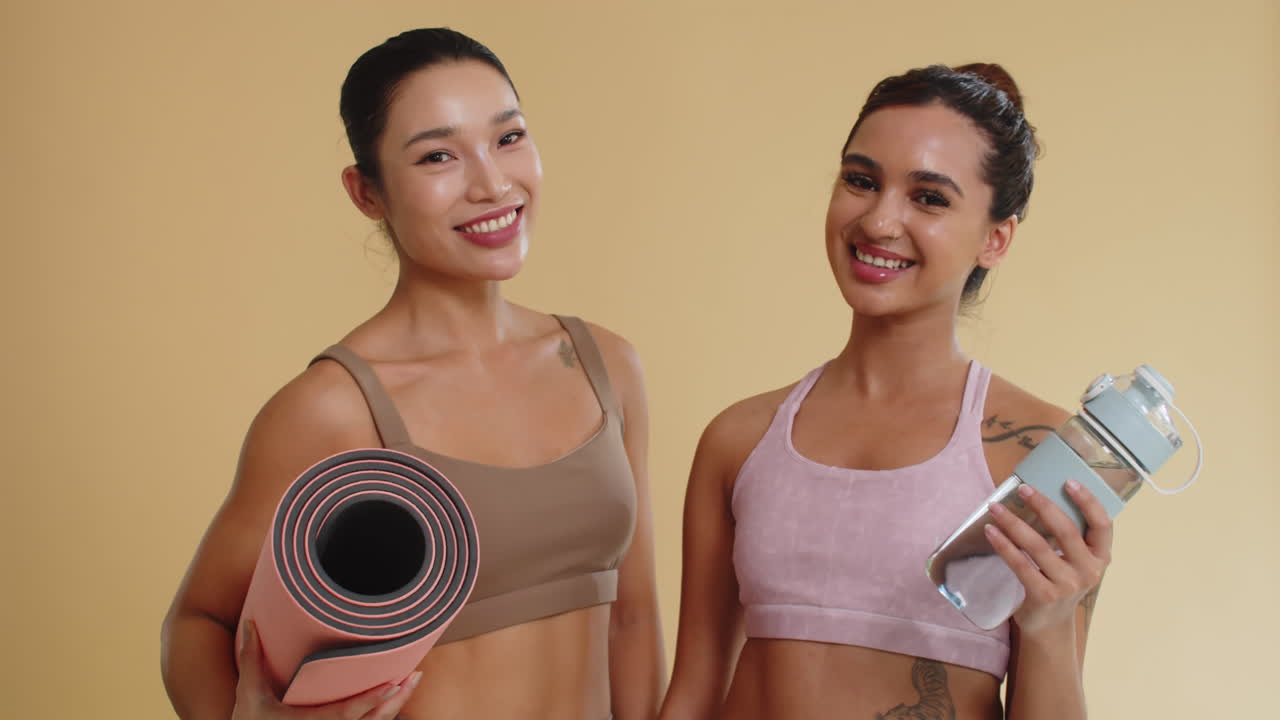 Portrait of Sportswomen with Yoga Mat and Bottle of Water on Yellow Background