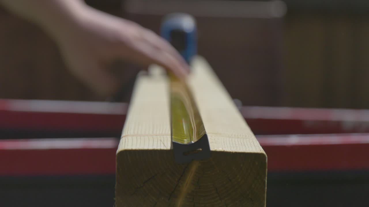 medir una longitud de 2x4 de madera con una cinta métrica