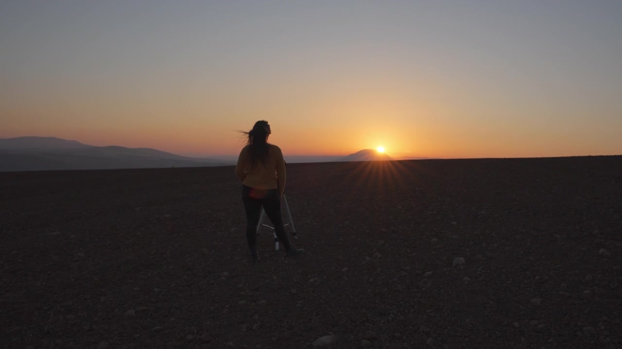 Donna che filma un tramonto con una fotocamera