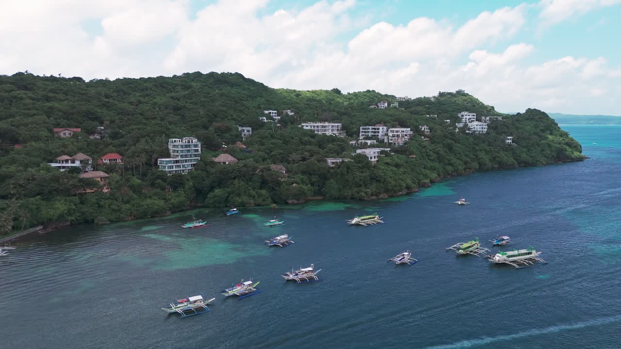 Drone view of Boracay’s hillside resorts, lush greenery, and boats cruising turquoise waters. Ideal for travel, tourism, adventure, and tropical lifestyle projects