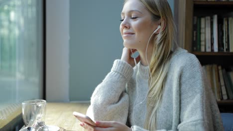 Woman-listening-to-music-and-looking-at-window