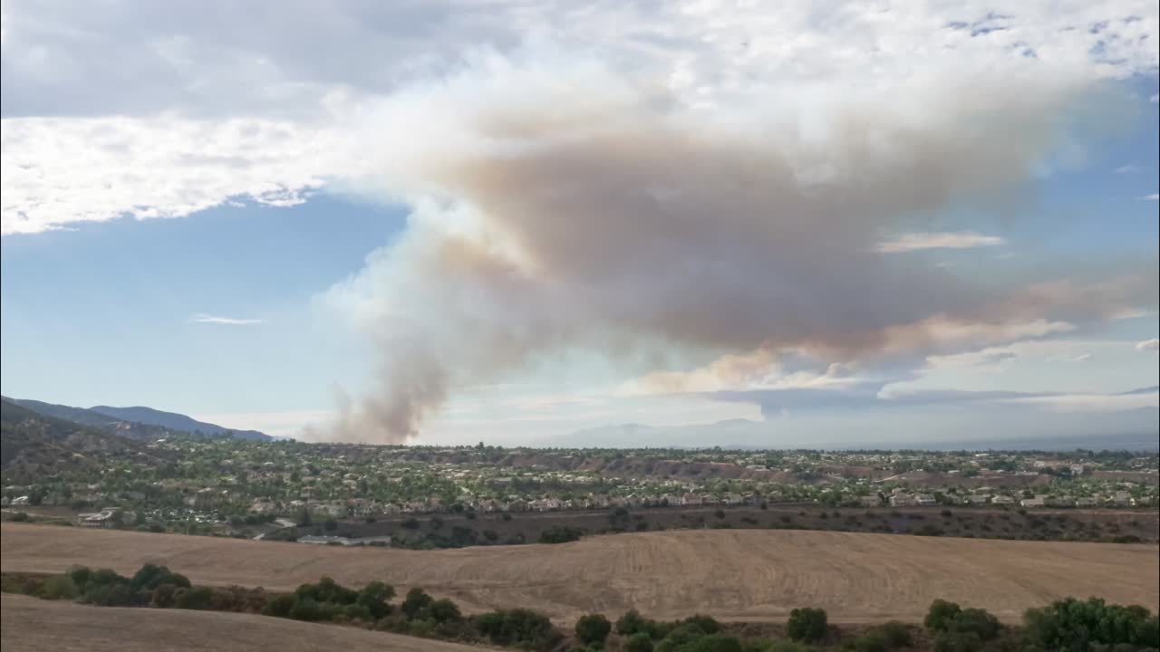 4K TIMELAPSE: A smokey summer brush fire by Skyline in the mountains of Corona California on a cloudy day