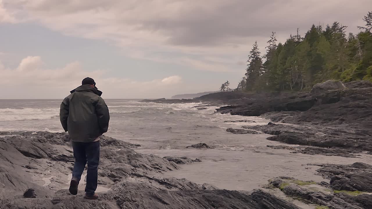 costa oeste de la isla de vancouver en port renfrew con un hombre mirando las olas