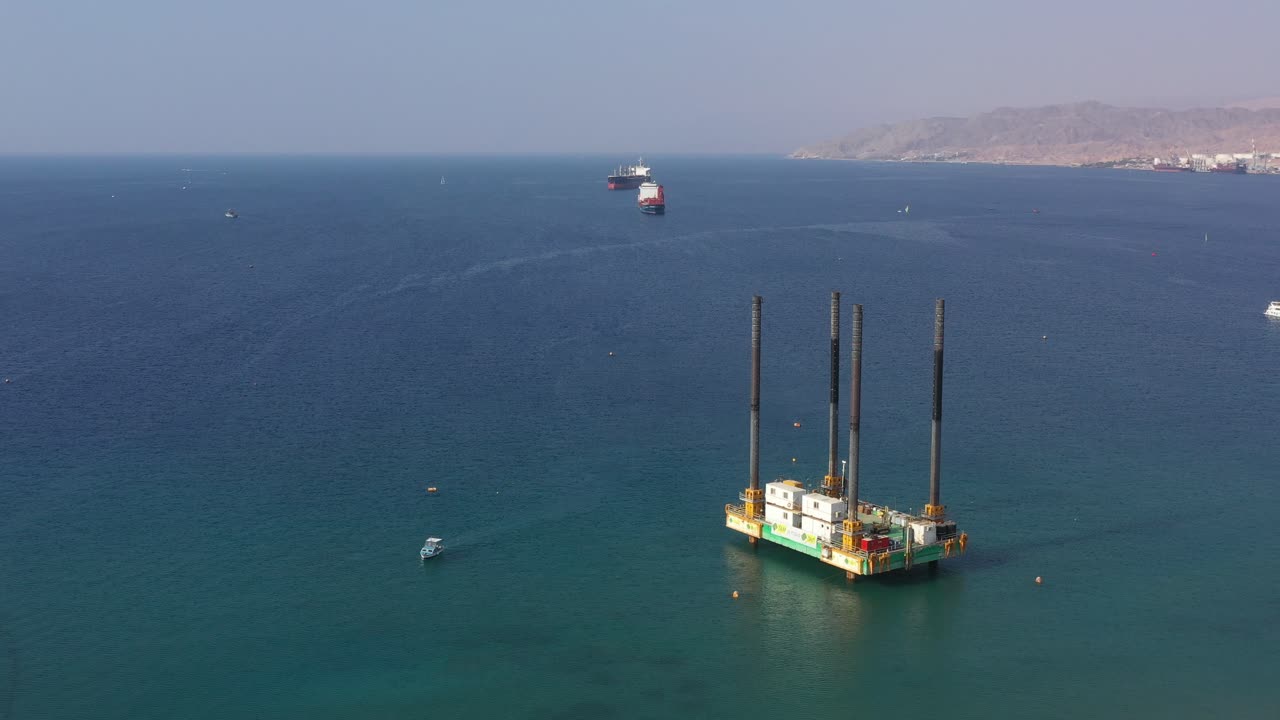 plataforma autoelevadora en alta mar o sep sobre grandes columnas delanteras para perforación marina en la ciudad de eilat, israel - órbita aérea alrededor