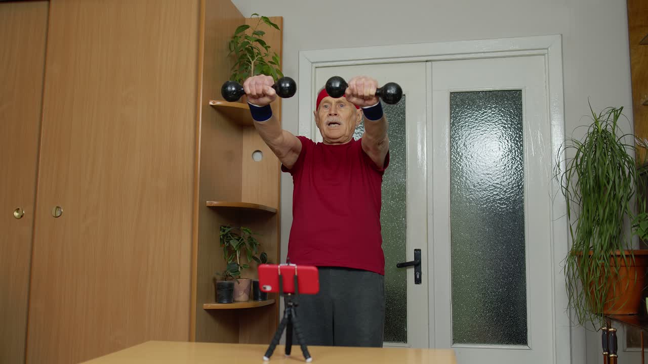Elderly man working out with dumbbells at home
