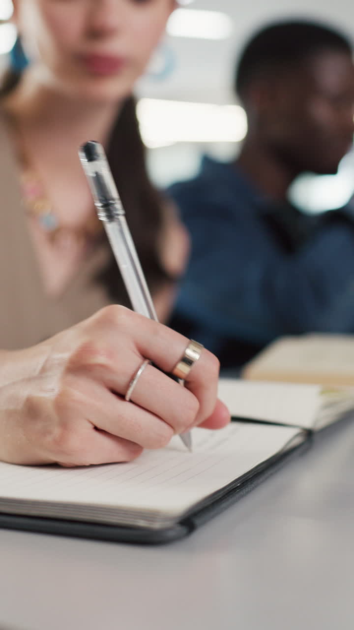 Close-up of a Student's Hand Writing Notes in a Notebook