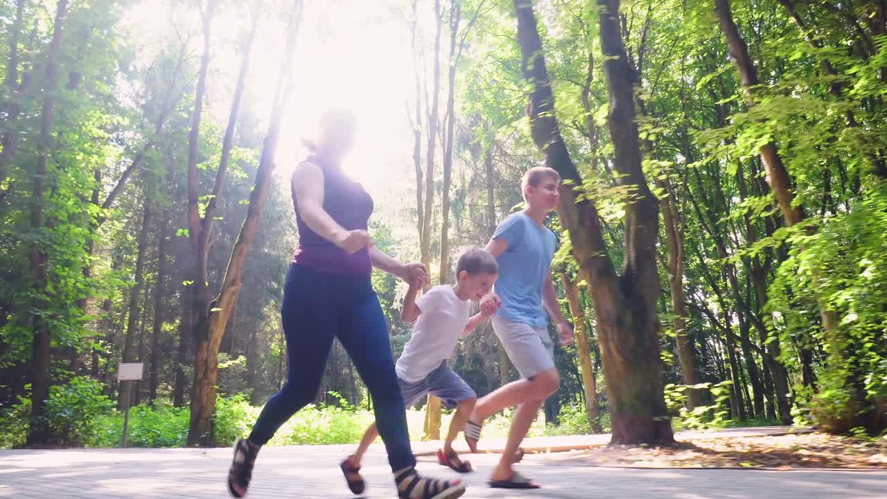 Una familia de tres corre por un sendero en el parque 04