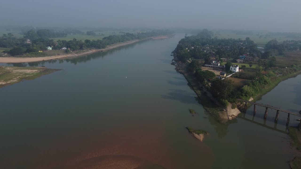Un fiume pieno di sabbia scorre attraverso un ambiente rurale