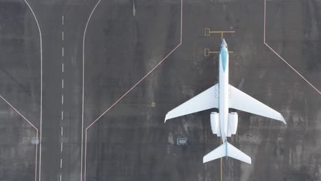 gulfstream g550 stands parked outside on tarmac of airport, top down aerial