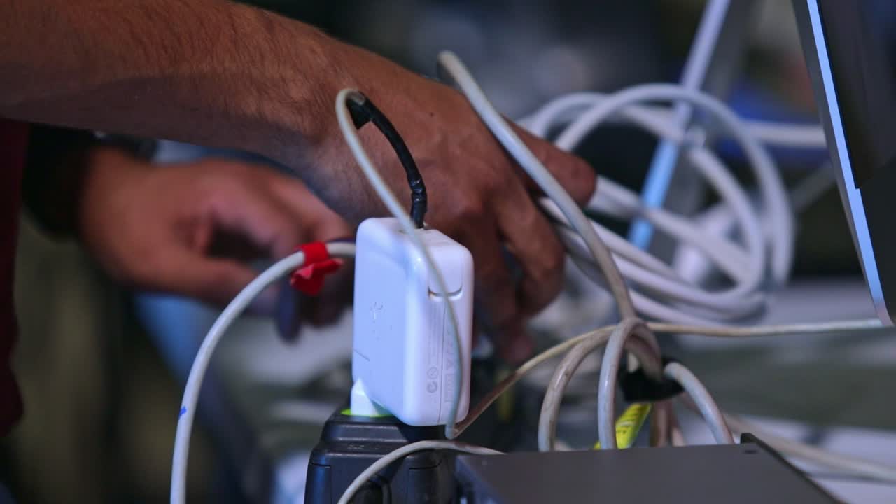 un miembro del equipo de televisión conecta los cables y se prepara para una transmisión en vivo
