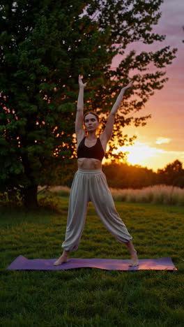 woman practicing yoga at sunset